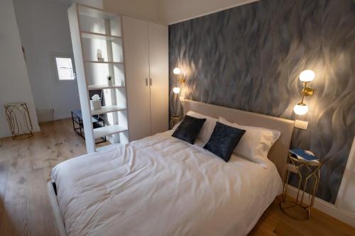 a bedroom with a white bed with two pillows at BF Glam-Apartments in Perugia