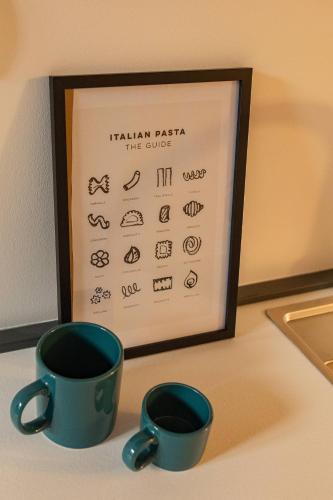two cups of coffee sitting next to a framed sign at BF Glam-Apartments in Perugia