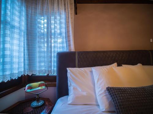 a bedroom with a bed with a window and a side table at KP113 All Season Villa in Makrinitsa in Makrinítsa