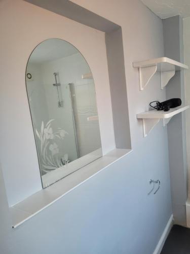 No 2 Decent Home -Large Deluxe bedroom في Dukinfield: مرآة على جدار في الحمام