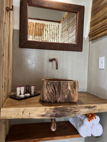 a bathroom with a wooden sink and a mirror at Vila Sereia Caraiva in Caraíva