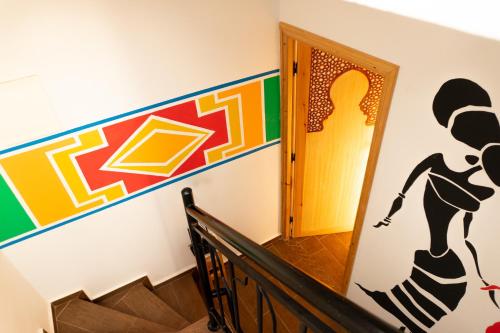 a staircase with a painting of a woman on the wall at Dar Mouja, eco-friendly home in Imsouane