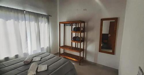 Sala de estar con cama y espejo en Magnolia's Cabañas en Tandil