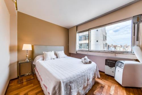 1 dormitorio con cama y ventana grande en Rivadavia 138 - B Centro - Elegante con Balcón y Vista en Córdoba