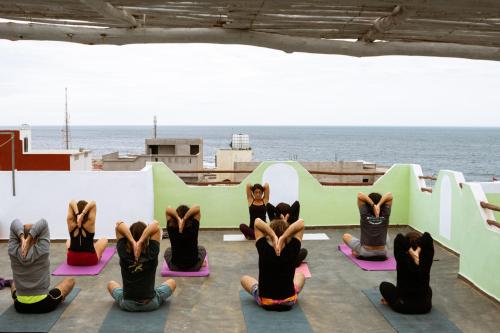a group of people in a yoga class looking at the ocean at Dar Mouja, eco-friendly home in Imsouane