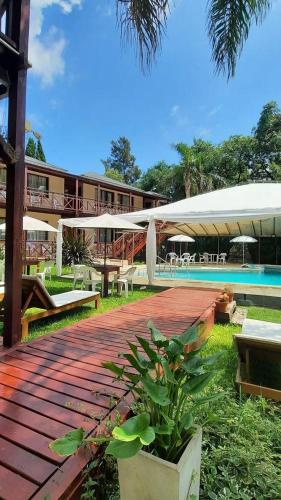 a building with a wooden walkway next to a swimming pool at Hotel Los Pinares in San Pedro