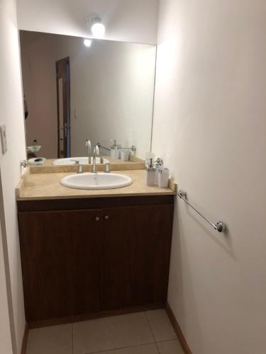 baño con lavabo y espejo grande en Departamento Bombal Sur en Godoy Cruz