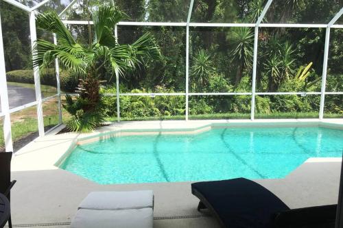 a swimming pool in a building with a large window at Family Villa with Private Pool near Disney Parks in Kissimmee