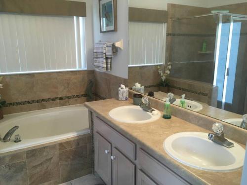 a bathroom with two sinks and a bath tub at Family Villa with Private Pool near Disney Parks in Kissimmee
