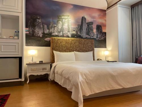 a bedroom with a bed and a painting on the wall at Wenpin Hotel - Pier 2 in Kaohsiung