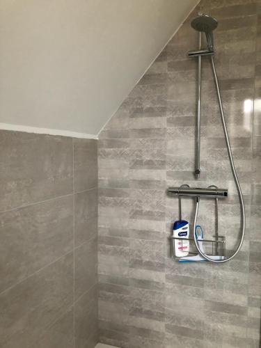 une douche dans une salle de bain avec un mur carrelé dans l'établissement Le Kesbel entre Strasbourg et Colmar en centre Alsace, à Lièpvre