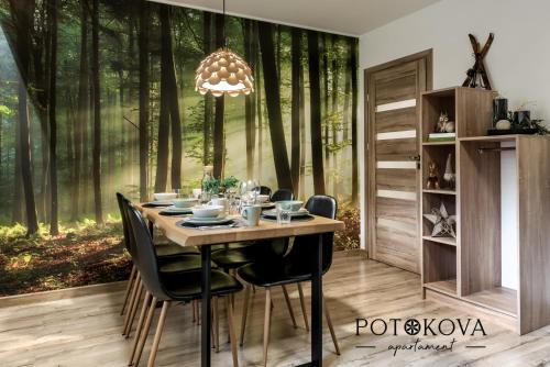 uma sala de jantar com uma mesa na floresta em Potokova apartament Centrum em Zakopane