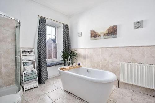 a bathroom with a tub and a toilet and a window at Georgian townhouse in centre of Perth in Perth