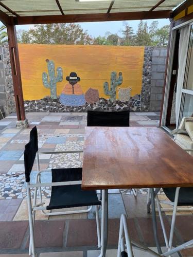una mesa y sillas en un patio con una pintura en Gratitud! en Almafuerte