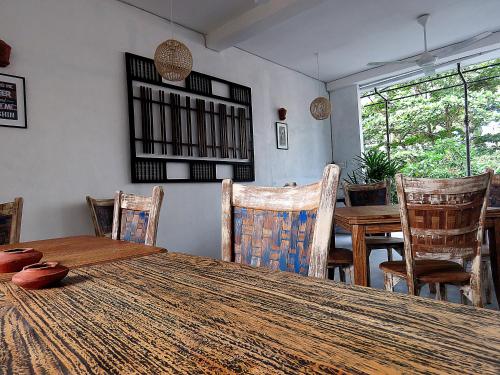 a dining room with a wooden table and chairs at H&C Heaven Beach Hotel in Unawatuna