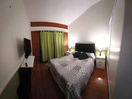 Dormitorio pequeño con cama y TV en La Estancita de Tanti con pileta in 