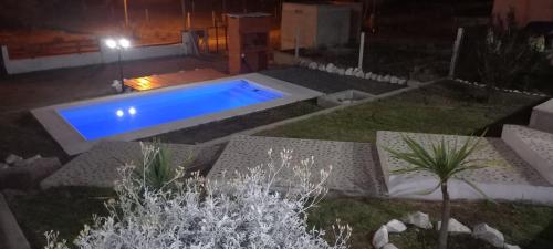 una piscina en medio de un patio por la noche en La Estancita de Tanti con pileta in 