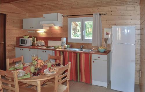 a kitchen with a table and a white refrigerator at Les Sgalires in Gramat
