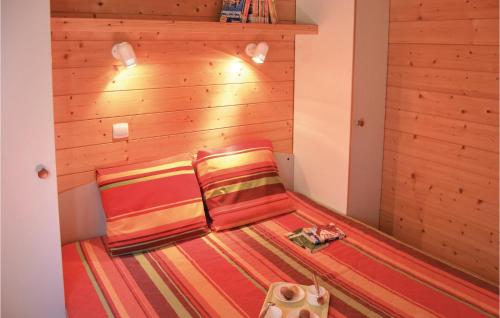 two beds in a room with wooden walls at Les Sgalires in Gramat