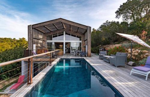 une maison avec une piscine à côté d'une terrasse en bois dans l'établissement Villa Leccia di Lorello, à Grosseto-Prugna