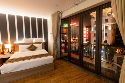 a bedroom with a bed and a large window at The One Hotel in Hai Phong