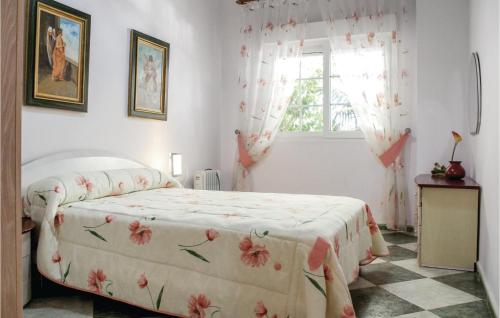 1 dormitorio con 1 cama con colcha de flores y ventana en Beautiful Home In Playa Honda With Jacuzzi, en Playa Honda