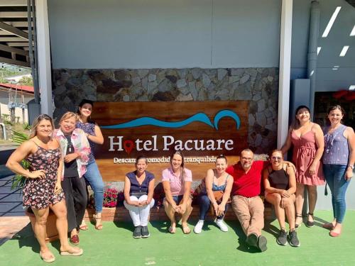 een groep mensen die poseren voor een foto voor een bord bij Hotel Pacuare Turrialba in Turrialba