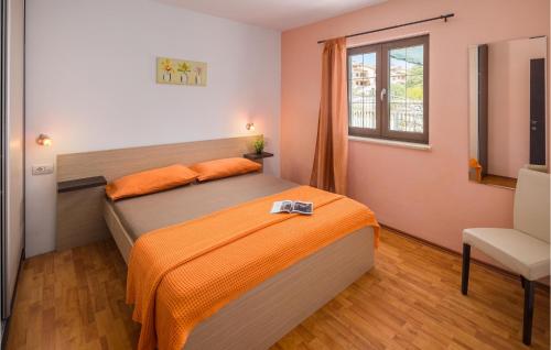 a bedroom with a bed with an orange blanket at 2 Bedroom Stunning Home In Liznjan in Ližnjan