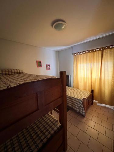 Un dormitorio con dos camas y una ventana. en Mirador, en Las Grutas