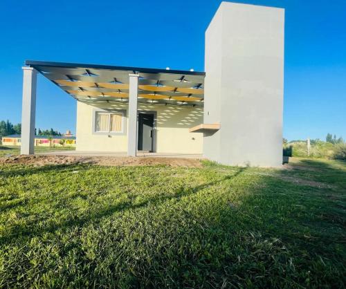 a building with awning over a grass field at Complejo Blend in San Rafael