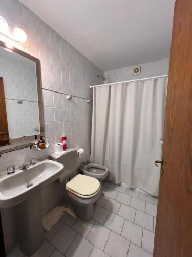 Un baño con un inodoro blanco y un lavabo. en Mirador, en Las Grutas