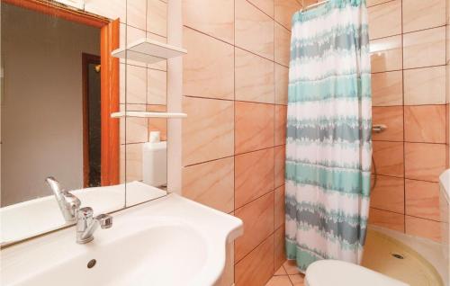 La salle de bains est pourvue d'un lavabo, de toilettes et d'un miroir. dans l'établissement Beautiful Apartment In Stanici With House Sea View, à Celina