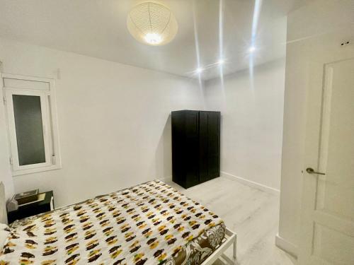 a bedroom with a bed with a black cabinet in it at Cozy Apartment Near Sagrada Familia in Barcelona