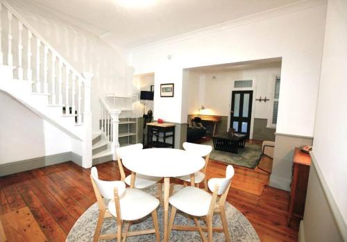 a living room with a white table and chairs at The Pavilion End - Central Paddington Apartment in Sydney