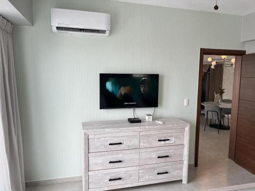 a white dresser with a tv on a wall at New: Centric, City View, SofaBd in Santo Domingo