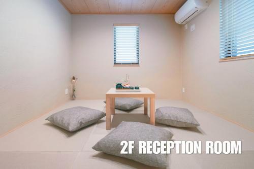 a room with a table and two ottomans at 新宿中心高級稀有新建別墅，JR線新大久保徒步4分鐘露台免費Wi-Fi in Tokyo