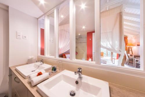 a bathroom with two sinks and a large mirror at PALM COURT RESIDENCE 4 Stars in Orient Bay
