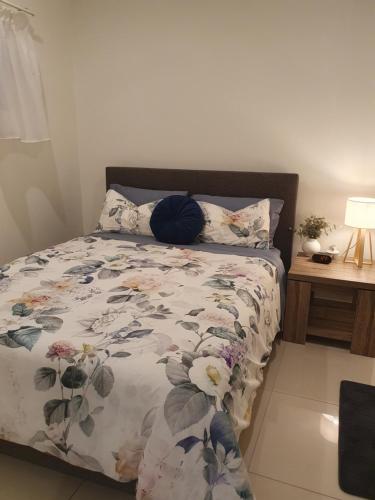 a bed with a floral comforter in a bedroom at Rosie's at Darwin in Darwin