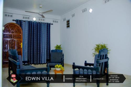 a room with two blue chairs and a door at Edwin Villa in Trincomalee