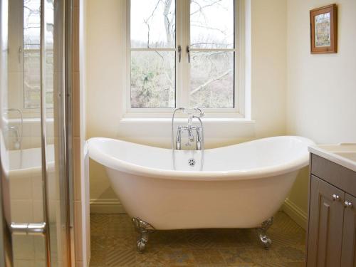 een badkamer met een wit bad en een raam bij Petham Hide in Petham