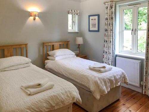 two beds in a bedroom with two towels on them at Petham Hide in Petham