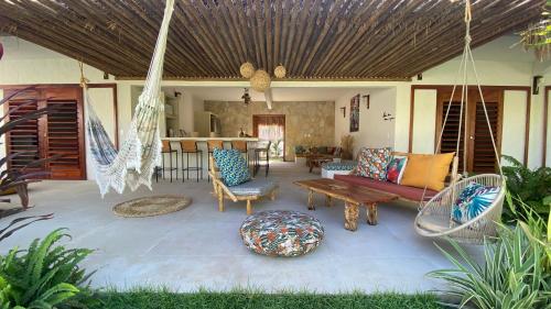 Casa Pura Vida - Icaraizinho في إيكاري: شرفة مع أرجوحة وغرفة معيشة