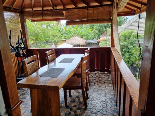 Suci's Friendly Appartment في ماتارام: طاولة وكراسي خشبية في غرفة مع نافذة