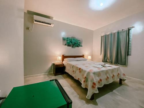um quarto com uma cama e uma mesa verde em Garden 437 Estúdios em Florianópolis