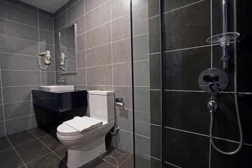 a bathroom with a toilet and a glass shower at Sunway Onsen Hospitality Suites in Ipoh