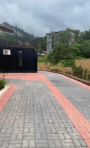 a cobblestone road with a fence on the side at The Black Box Villa - Genting Highland Foot Area in Bentong