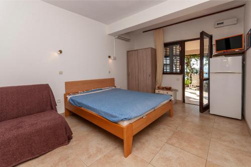 1 dormitorio con cama y sofá en Apartments Mladen, en Pisak