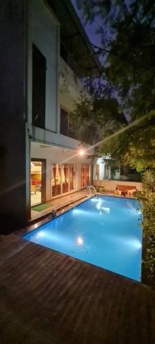 a large blue swimming pool in front of a house at Modern Villa One in Lonavala