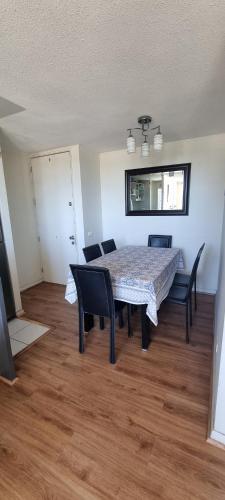 a dining room table and chairs in a room at Edu Apartment in Concepción