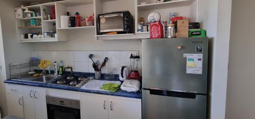 cocina con nevera de acero inoxidable y fregadero en Edu Apartment, en Concepción